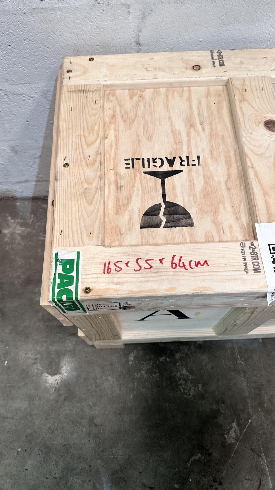Handwritten dimensions and fragile labels on a wooden crate, with JLog stencilling